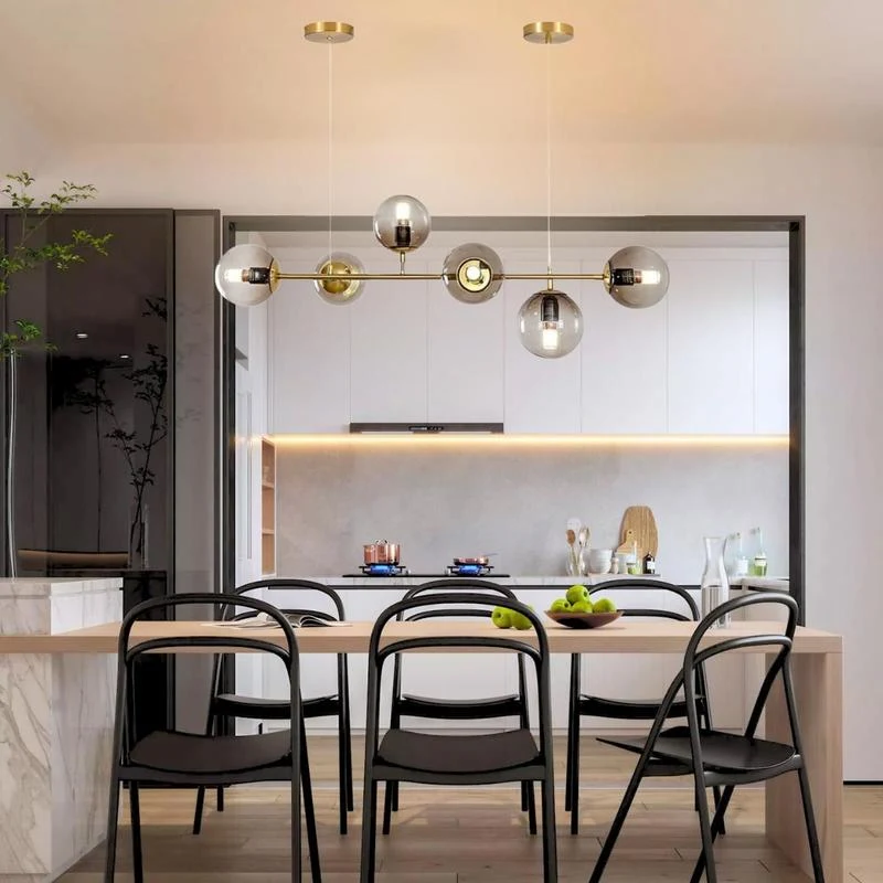Pendente dourado de seis globos instalado sobre uma mesa de jantar